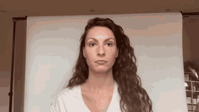 a woman in a white shirt is standing in front of a white background .