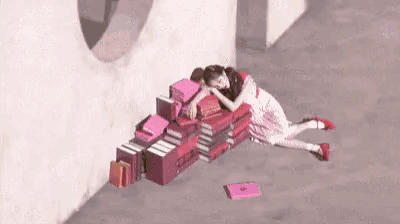 a woman is laying on the ground next to a pile of books including one that says ' a woman ' on it