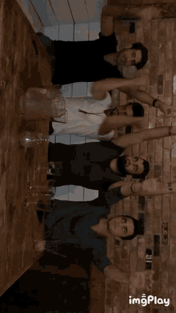 a group of men are standing around a table with their arms out