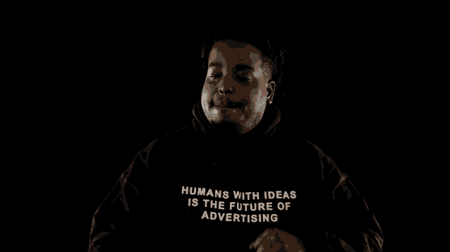 a man wearing a black sweatshirt that says humans is the future advertising