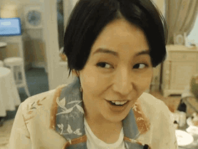 a close up of a woman 's face with a white shirt and a jacket
