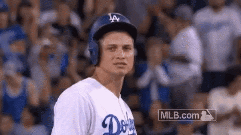 a baseball player wearing a helmet and headphones is standing in front of a crowd .