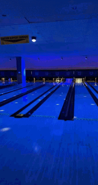 a man in a nike shirt is bowling on a bowling alley