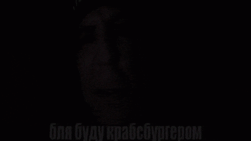 a man wearing a black hat and ear plugs is crying in the dark .