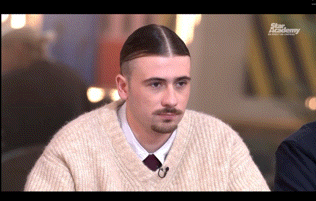 a man wearing a sweater and tie is on a tv show called the star academy