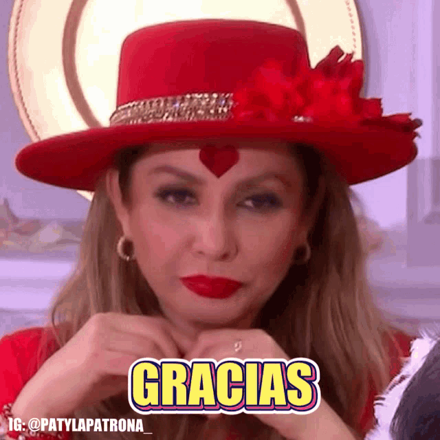 a woman wearing a red hat has the word gracias on her face