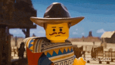 a lego cowboy with a mustache is standing in the desert wearing a sombrero and poncho .