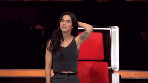 a woman with a tattoo on her arm is sitting in a chair
