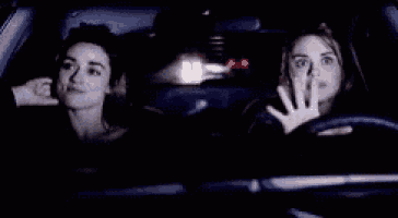 two women are driving a car at night .