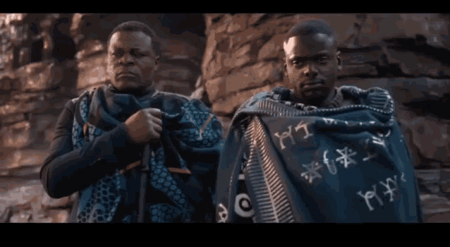 two men standing next to each other with one wearing a blanket that says ' y ' on it