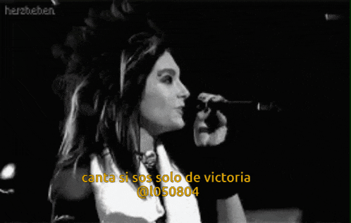 a woman singing into a microphone with the words canta si sos solo de victoria @ 1050804