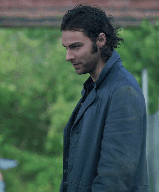 a man in a blue jacket is looking down