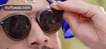a close up of a man wearing sunglasses and a turban on his head .