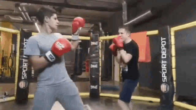 a man wearing everlast boxing gloves is fighting another man in a gym