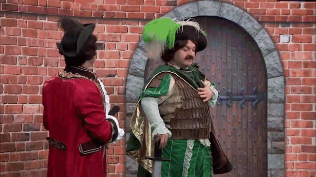 a man in a green costume is standing next to a man in a red costume