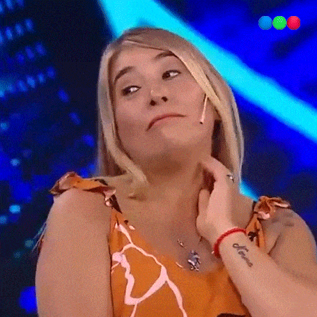 a woman is making a funny face while holding her neck .