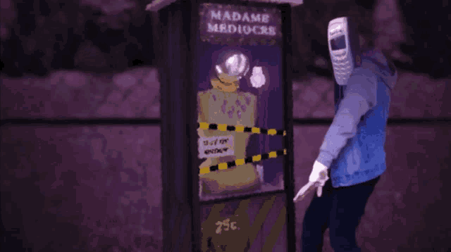 a man with a cell phone on his head stands in front of a phone booth that says madame mediocre