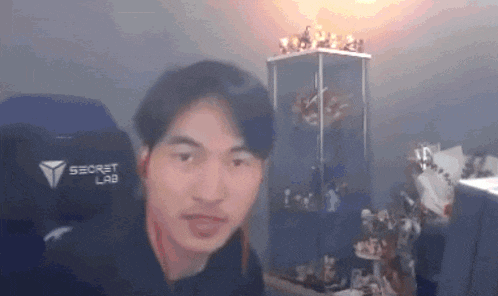 a man wearing a black secret lab chair looks at the camera