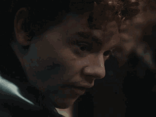 a close up of a man 's face with a black jacket on
