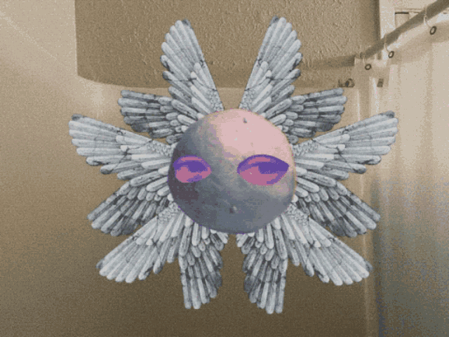 a drawing of a star with wings and a face on it hangs from a shower curtain