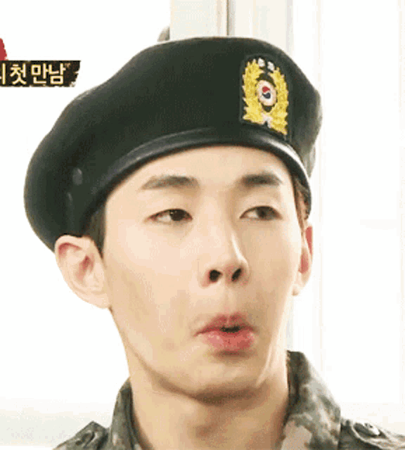 a close up of a man wearing a beret with a korean symbol on it
