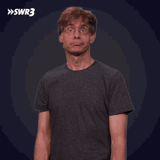 a man in a gray shirt is pointing up with a swr3 logo behind him