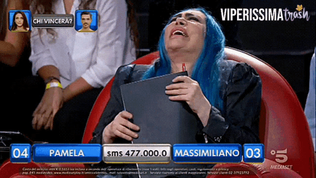 a woman with blue hair is sitting in front of a screen that says pamela massimiliano