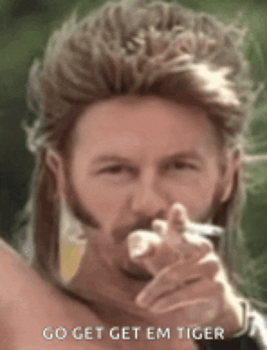 a man with a mullet and a beard is smoking a cigarette and pointing at the camera .
