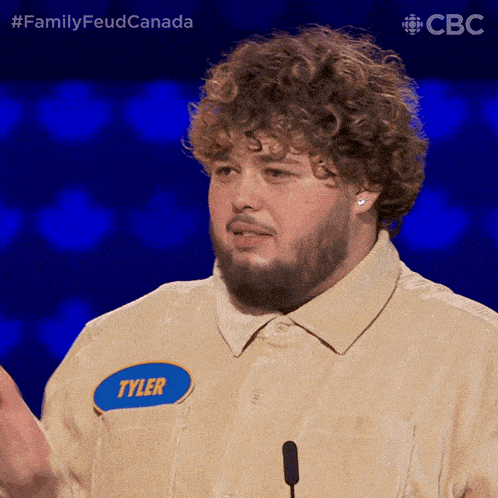 a man with a beard and a name tag that says tyler