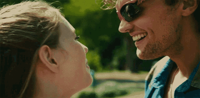 a man and woman are looking into each other 's eyes and smiling