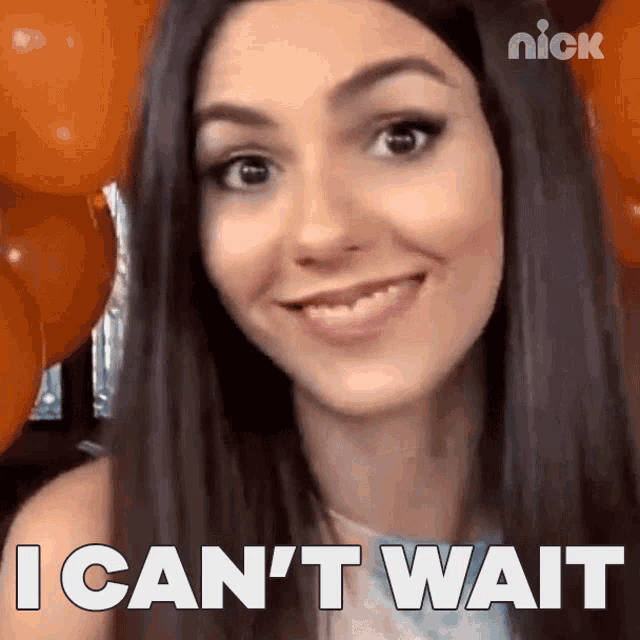victoria justice is smiling and says " i can 't wait " in front of orange balloons