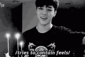 a black and white photo of a young man standing in front of candles and saying `` it tries to contain feels '' .
