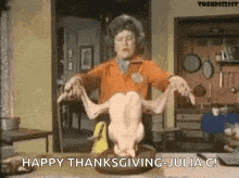 a woman is holding a turkey in her hands and says `` happy thanksgiving julia c ! ''