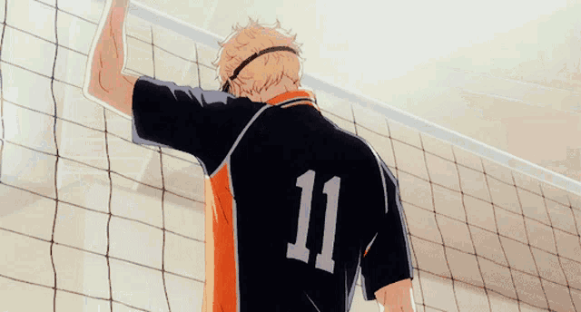 a man wearing a black and orange shirt with the letter o on the back