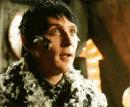 a close up of a man with feathers on his face