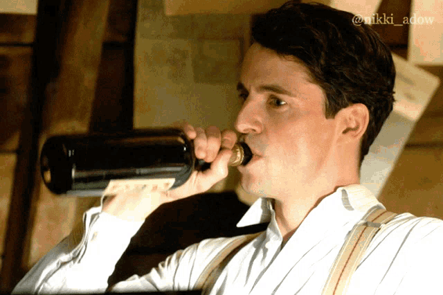 a man drinking from a bottle with the name nikki adow on the bottom left