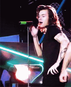 a man with long hair singing into a microphone