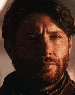 a man with a beard is looking at the camera