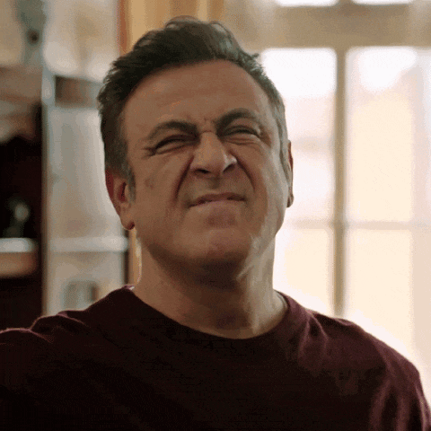 a man in a red shirt is making a face