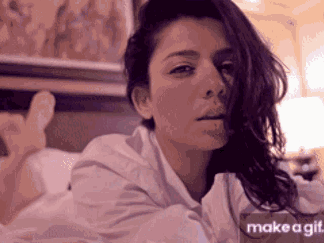 a woman laying on a bed with a make a gif button
