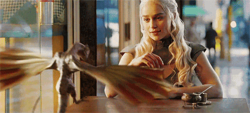 a woman is sitting at a table with a dragon on it 's wings .