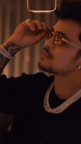 a close up of a man wearing sunglasses and a rolex watch