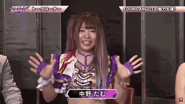 a woman with purple hair is smiling in front of a sign that says cosmic angels on it