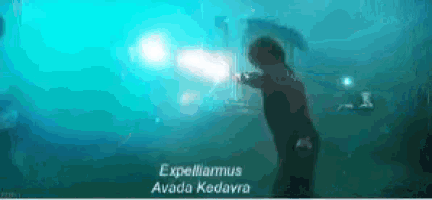 a person is holding a sword in a dark room with a light coming out of it .