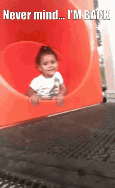 a little girl is going down a slide with the caption " never mind i 'm back "