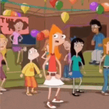 a group of people are standing in a room with balloons hanging from the ceiling .
