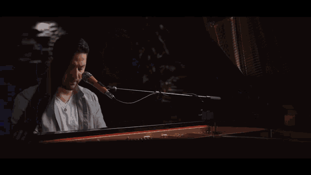 a man is playing a piano with a microphone attached