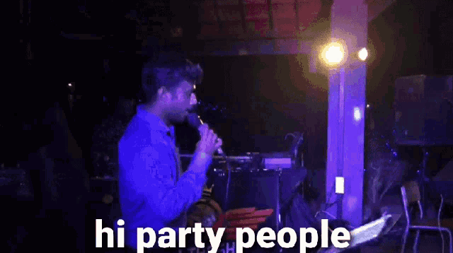 a man singing into a microphone with the words hi party people written above him