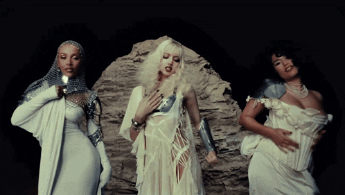 three women are standing next to each other in white dresses