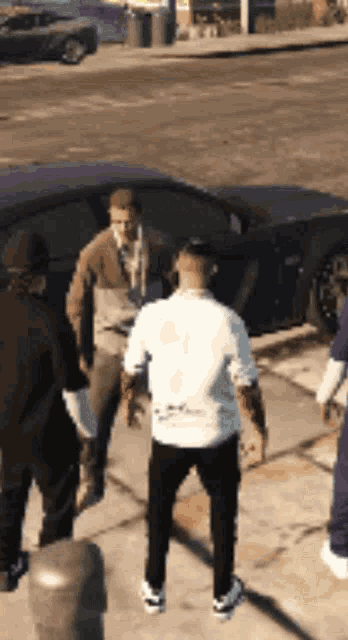 a group of people standing on a sidewalk in front of a car
